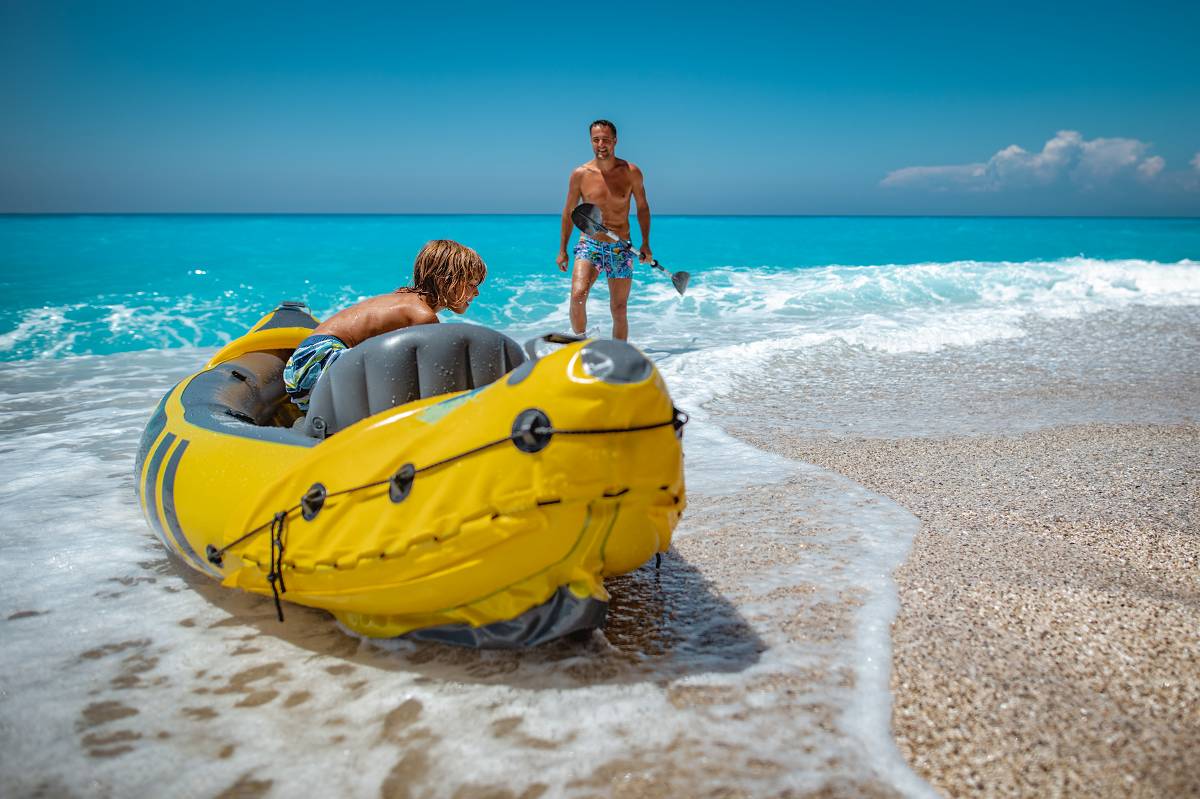 Spend your days visiting tropical islands Father and son enjoy kayaking to the beach from their bug-out boat